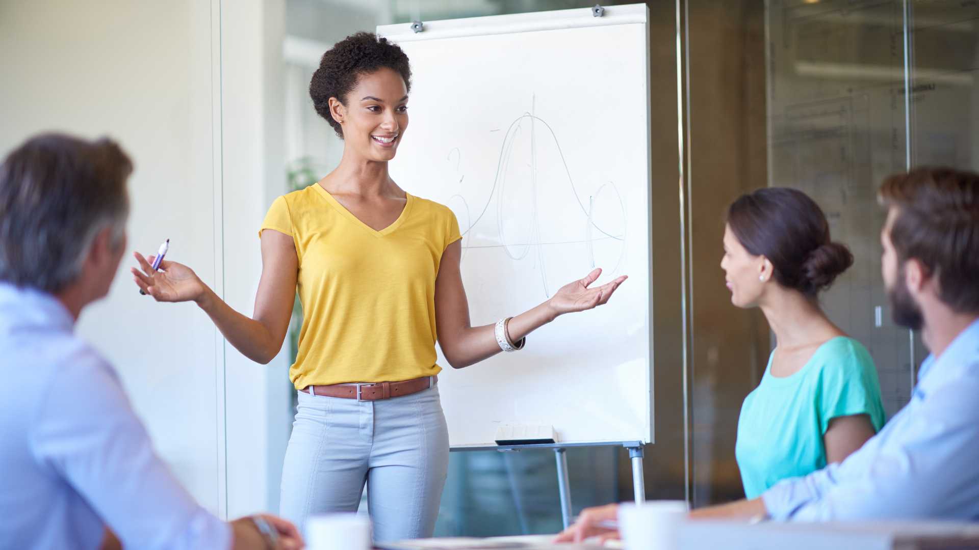 Atelier Pitch authentique Jeune femme devant un tableau en train de faire un pitch