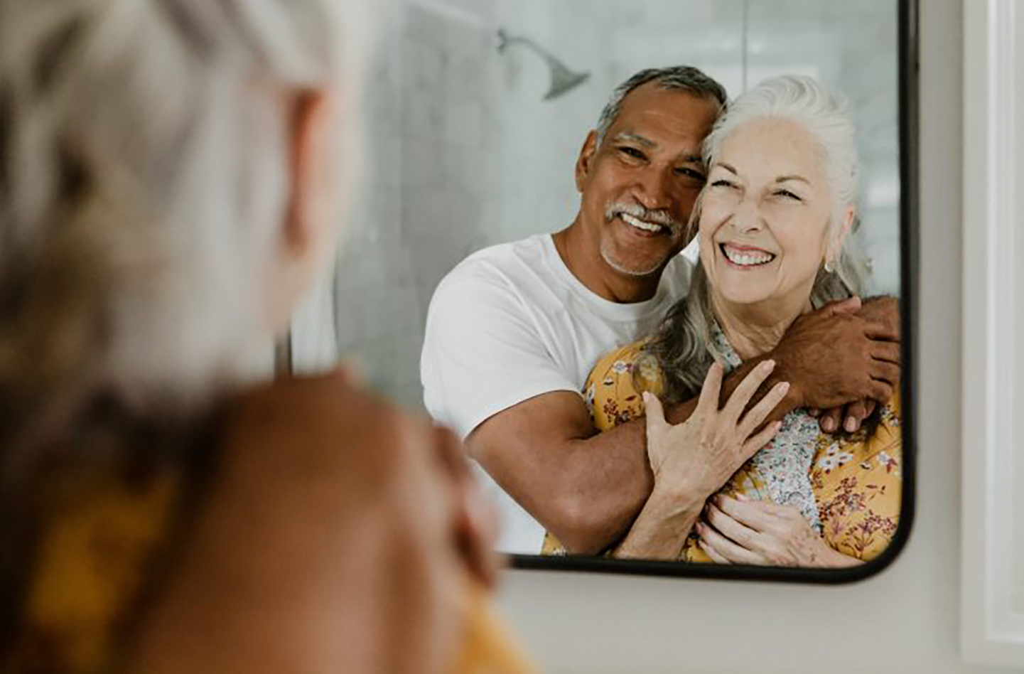 seniors souriants devant un miroir