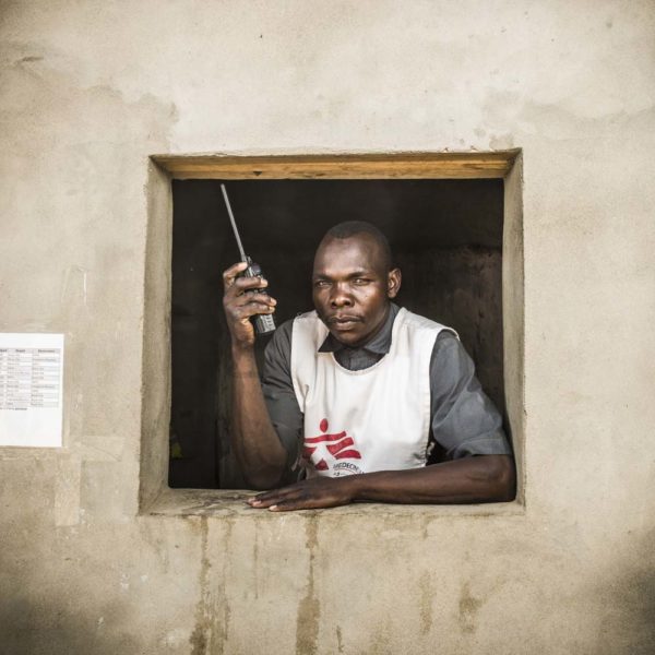 Photo de Corentin Fohlen Un bénévole tchadien de Médecins Sans Frontières pose à une fenêtre en tenant le volet.