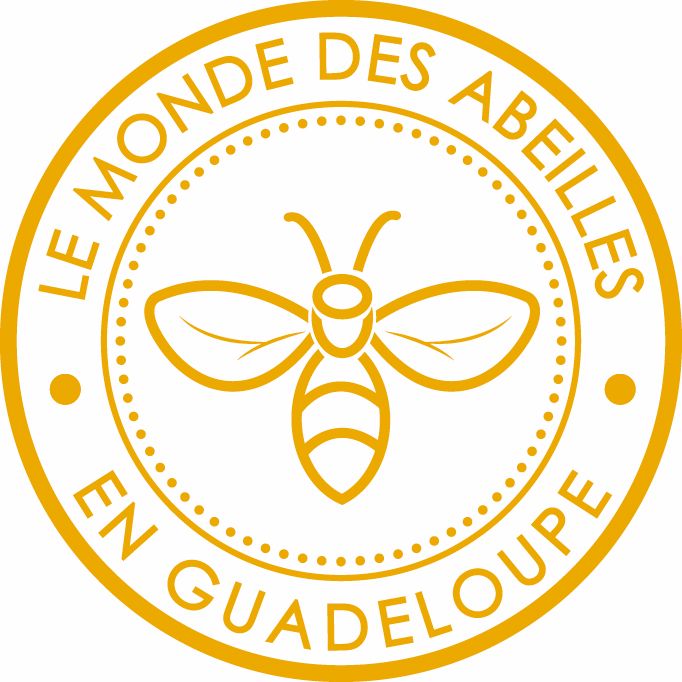 Autour de ce dessin, dans un cercle externe, figure l’inscription « LE MONDE DES ABEILLES EN GUADELOUPE », écrite en lettres majuscules, formant une bordure autour de l’abeille. Deux petits points séparent le début et la fin du texte pour fermer le cercle visuel.