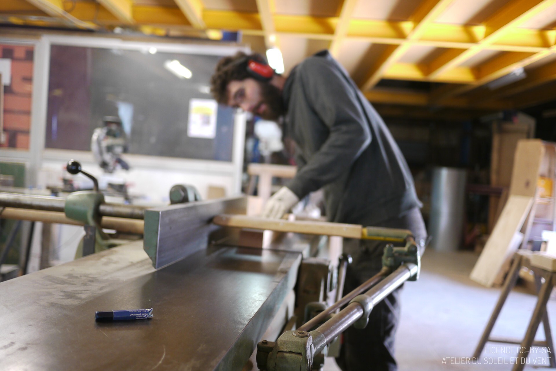 En action lors d'une initiation menuiserie travail du bois / dégauchisseuse